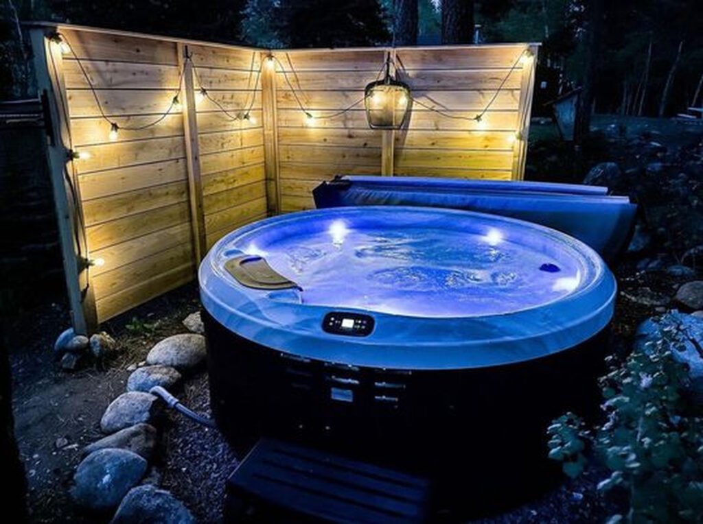 Bullfrog Spas X6R – jacuzzi ogrodowe Alt: Bullfrog Spas X6R – okrągłe jacuzzi ogrodowe z podświetleniem wieczorem